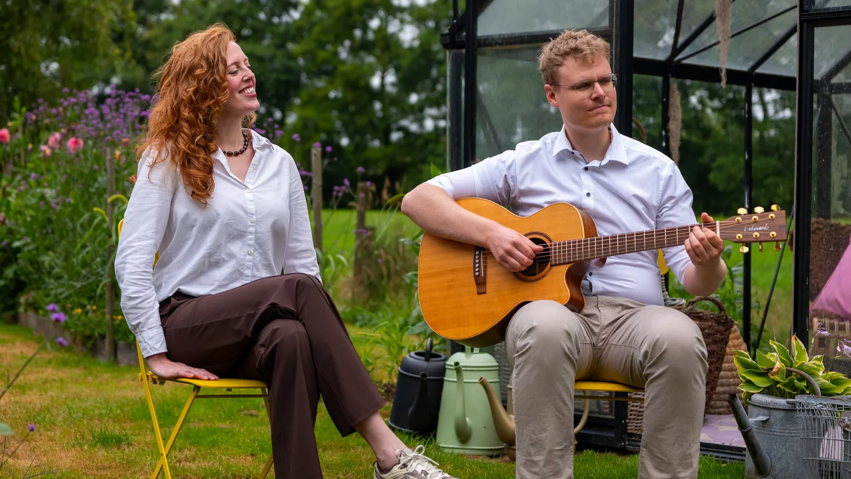 Timo speelt gitaar terwijl Liza meezingt in de tuin