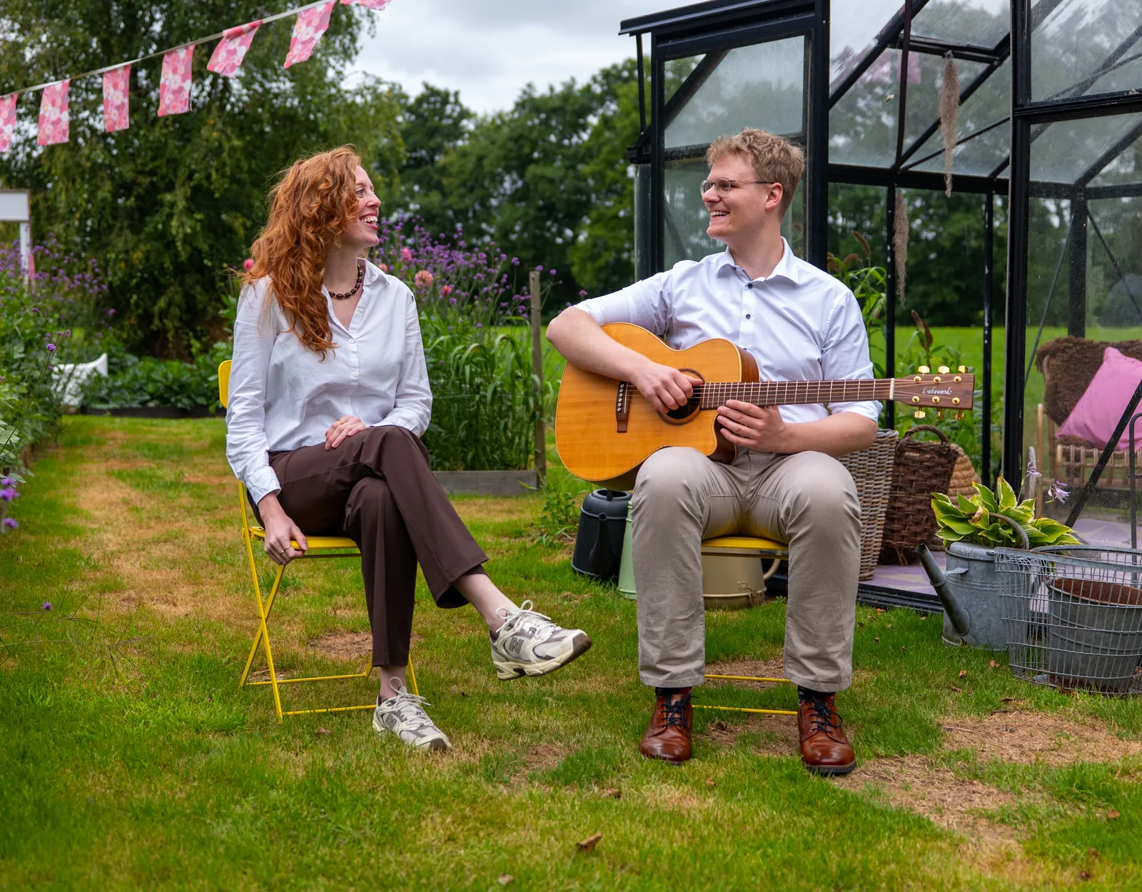 Liza en Timo van Bloom Acoustic kijken elkaar lachend aan in een bloementuin